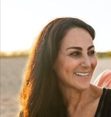 A woman with long hair is smiling for the camera