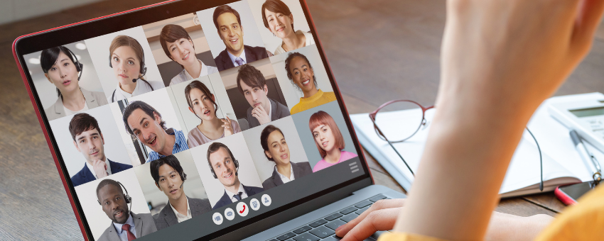 A person is using a laptop computer to have a video call with a group of people.