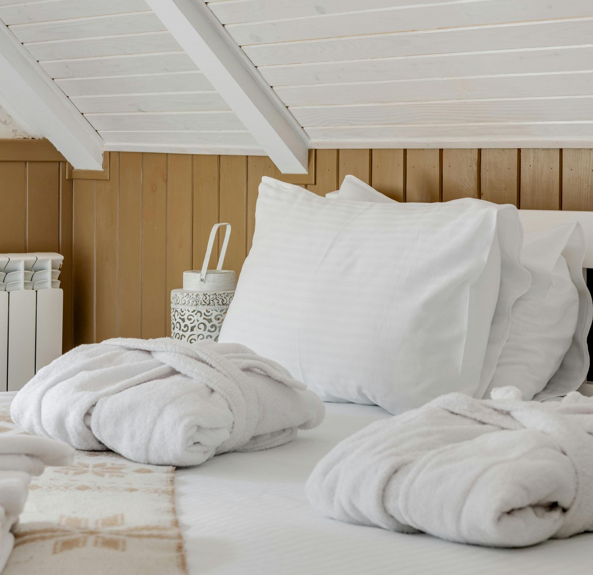 A bed with white sheets and pillows in a bedroom
