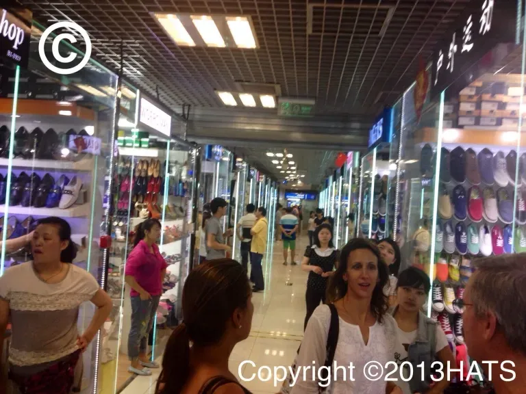 A group of people are walking through a shopping mall ..