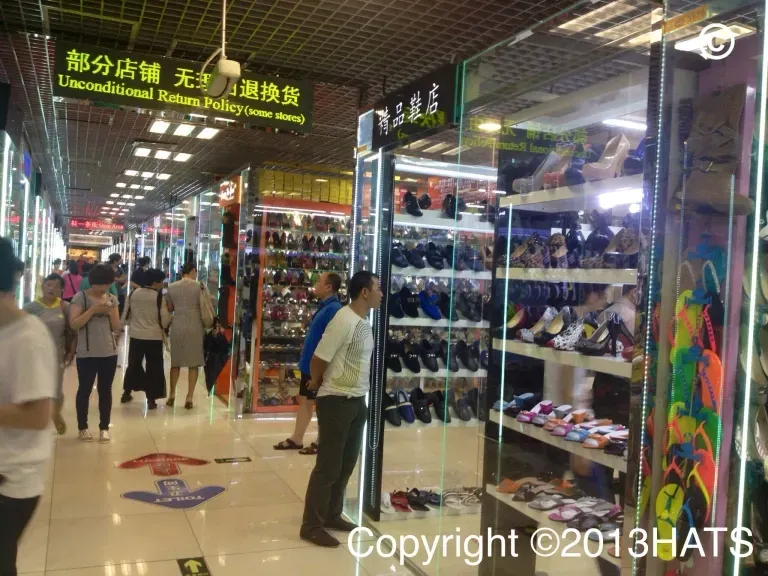 A man standing in front of a store with a sign that says copyright 2013hats