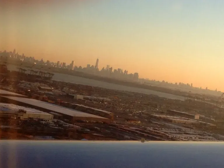 A view of a city from an airplane window at sunset.