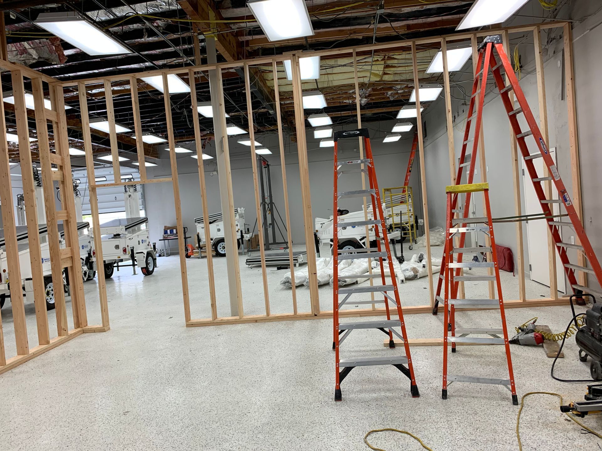 A ladder is sitting in the middle of a room under construction.