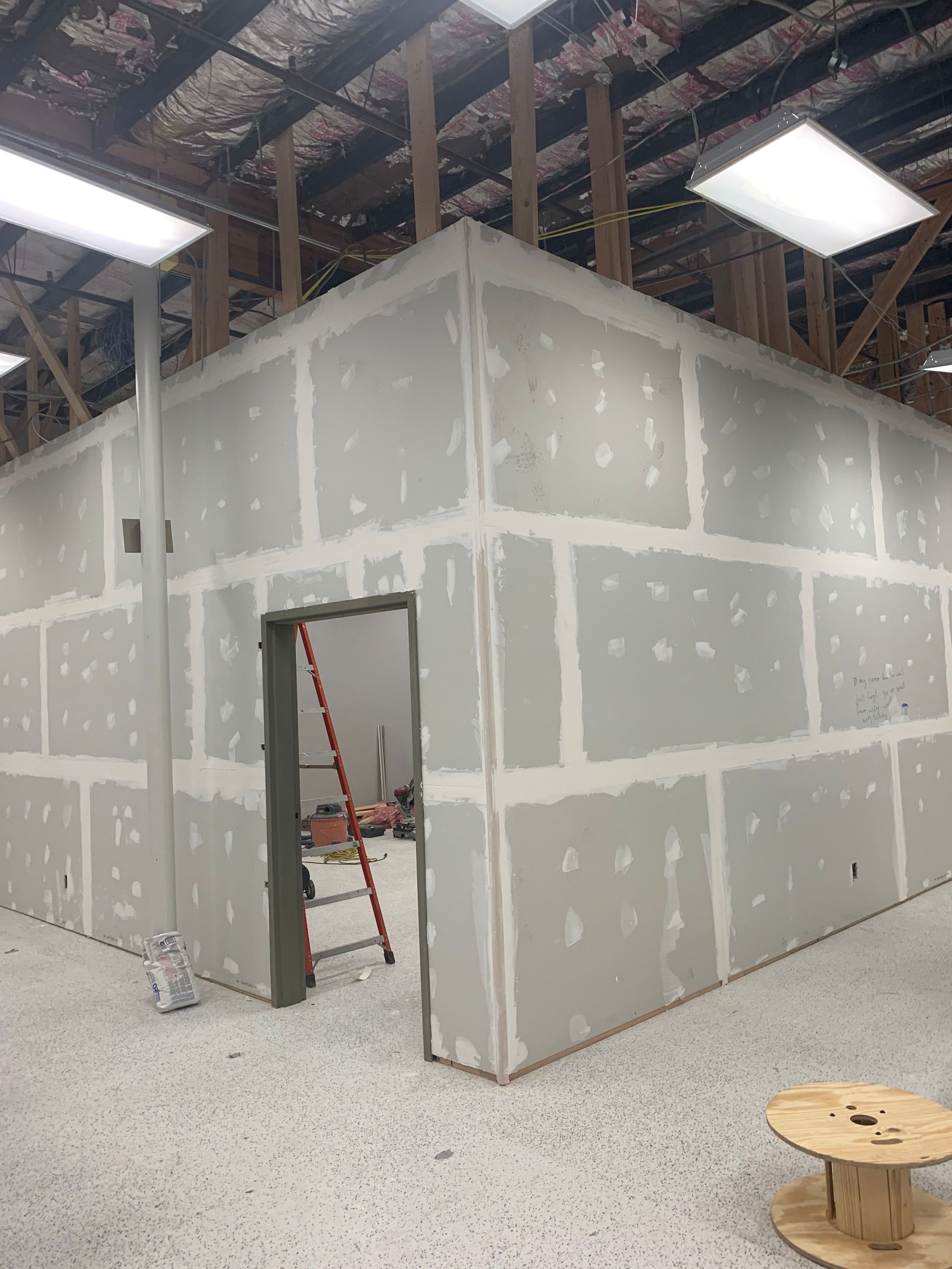A room with drywall walls and a door.