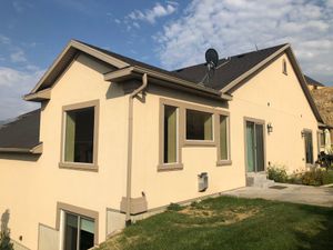 The back of a house with a lot of windows and a satellite dish on the roof.
