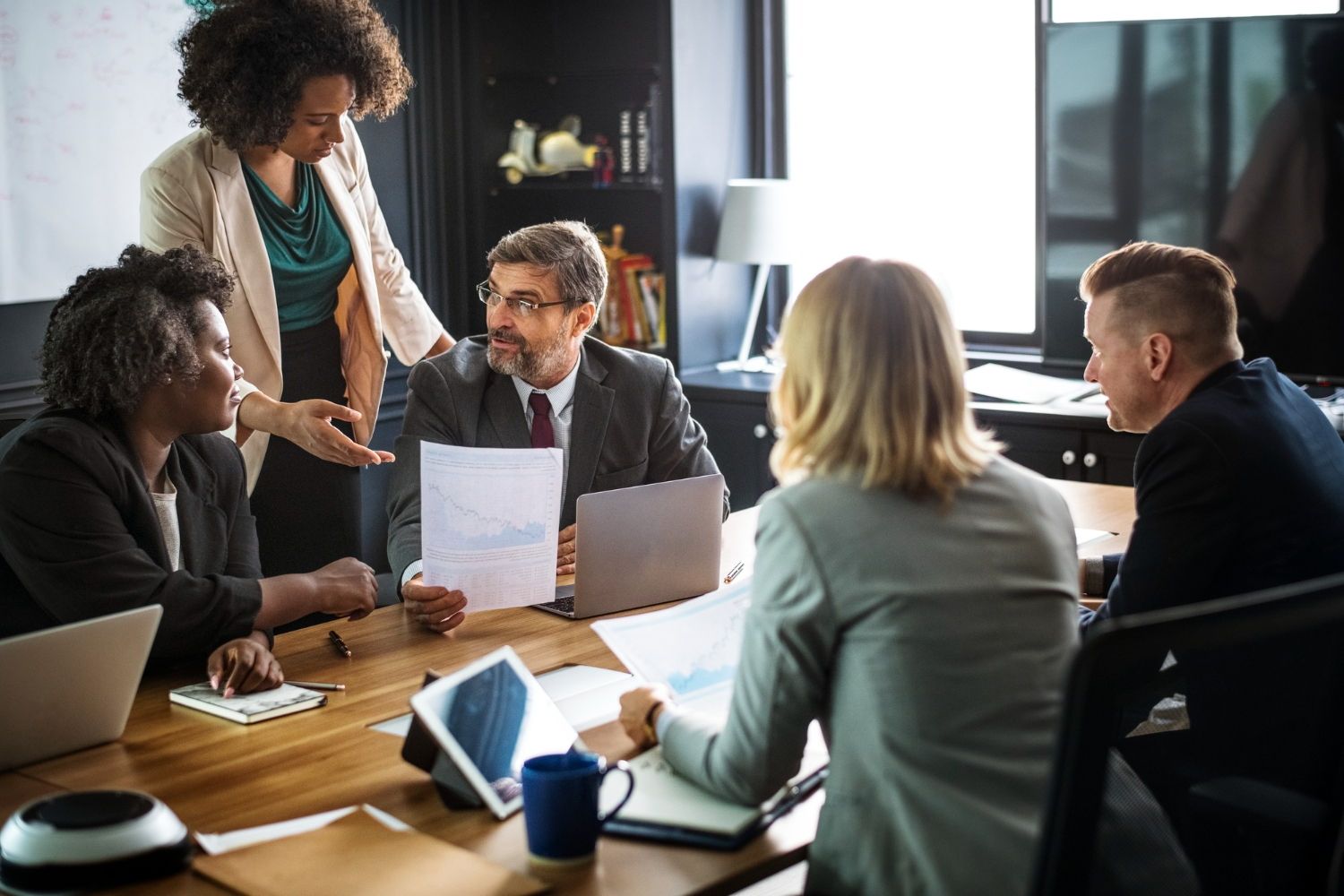 A group of people are sitting around a table having a meeting.