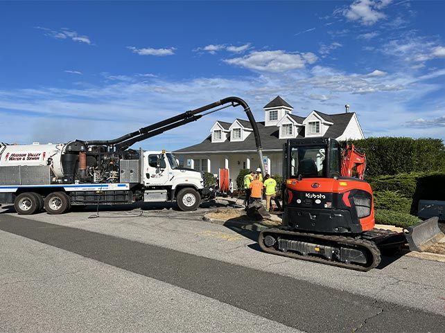 A truck with a crane attached to it is parked in front of a house.