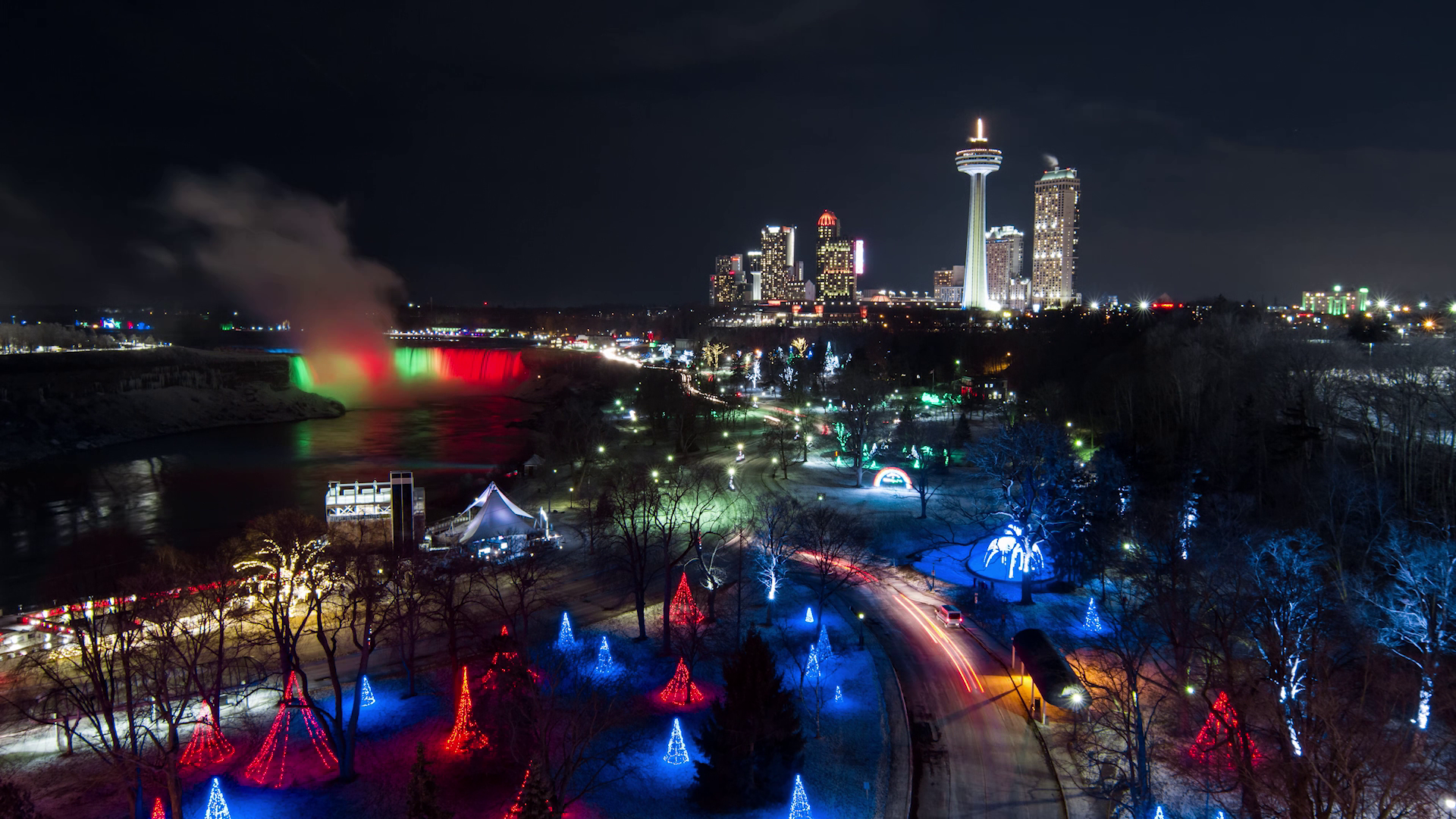 Aerial view of Niagara Falls lit up at night by Christmas displays