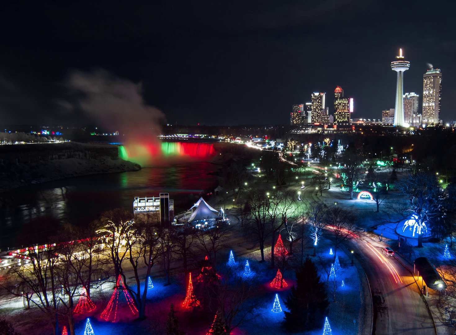Aerial view of Niagara Falls lit up at night by Christmas displays