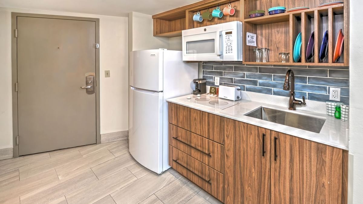 Modern kitchen with wood cabinets, white appliances, sink, and open shelving