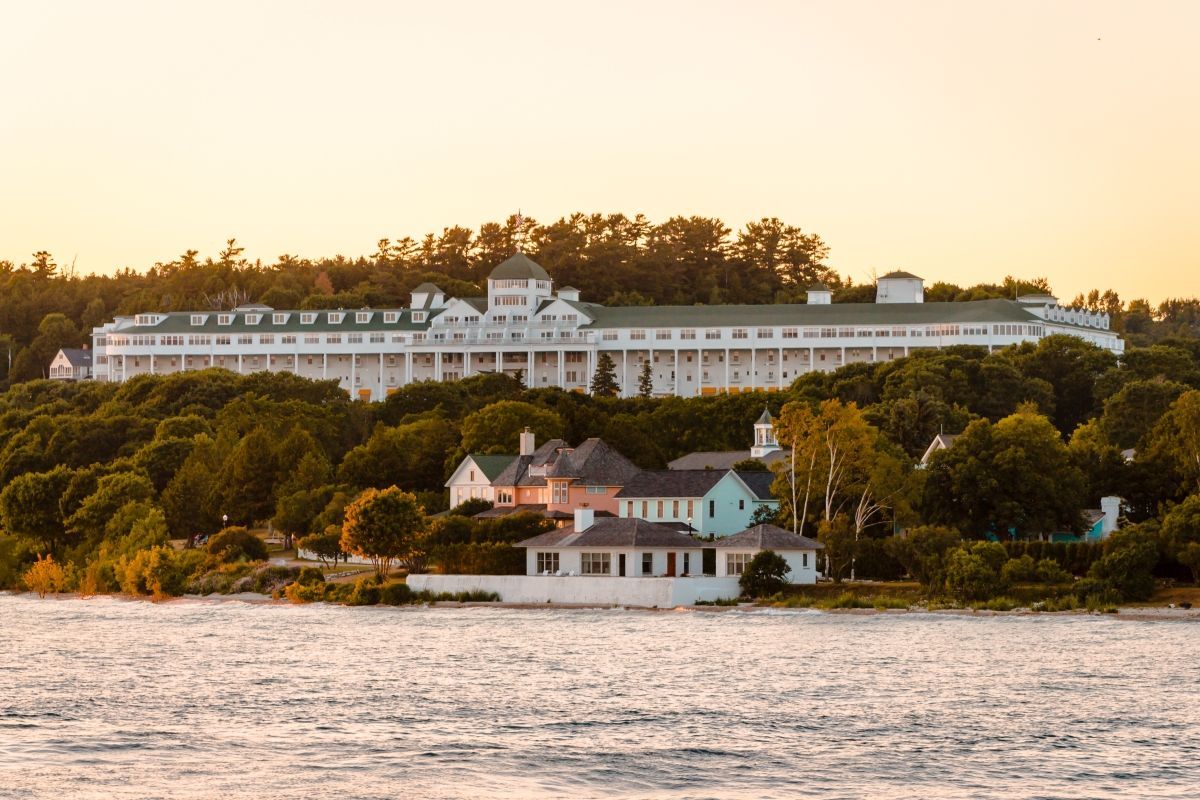 White Grand Hotel on a hill overlooking water during a sunset.