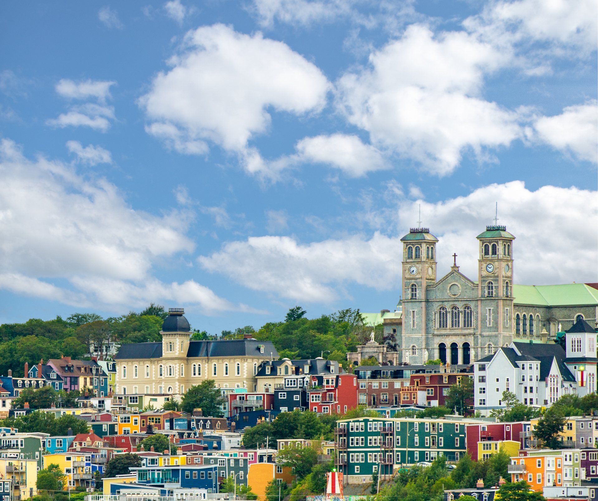 Colorful buildings and church under blue sky with clouds in St. John's, Newfoundland.