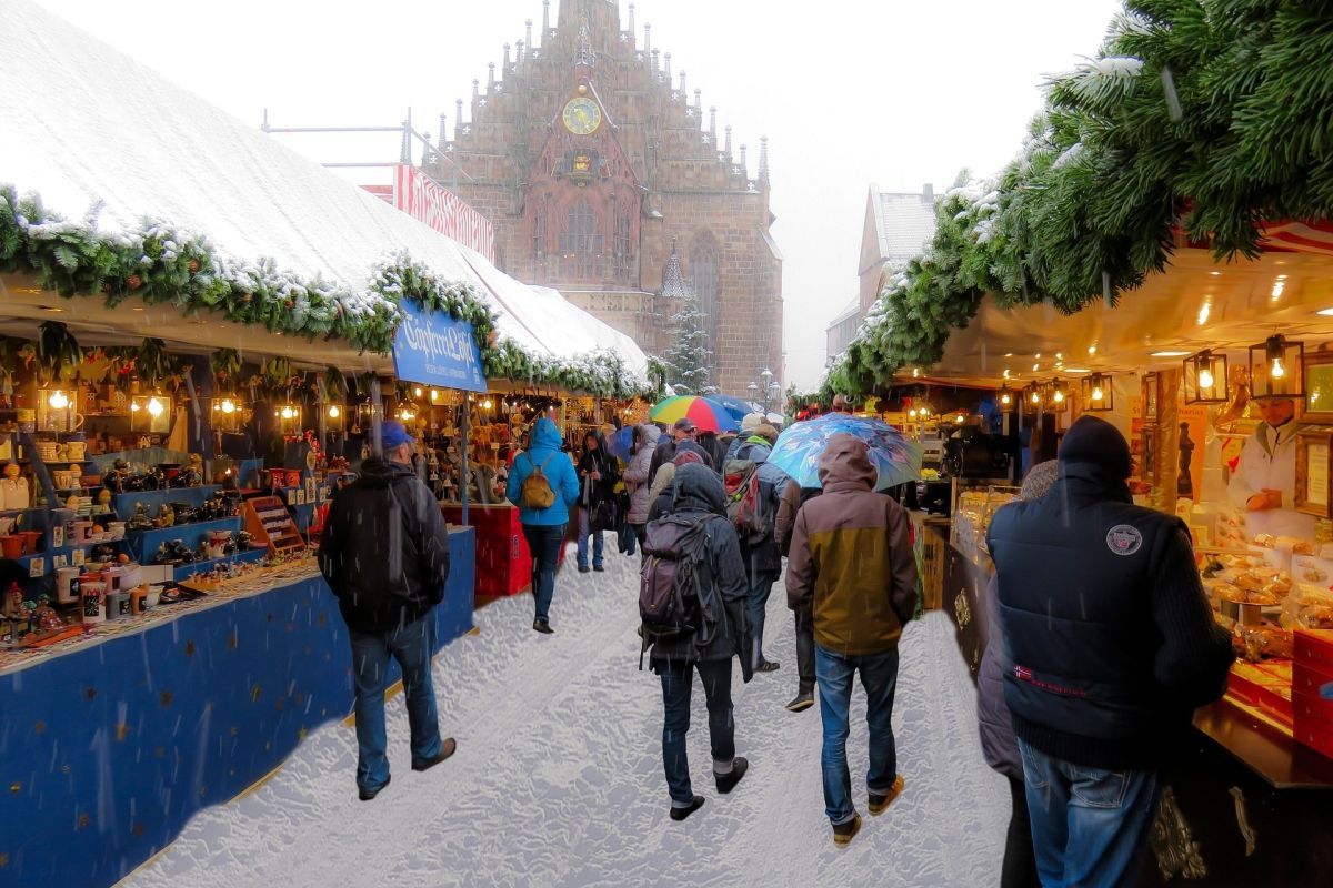 Christmas market in Nuremberg, Germany, with people browsing stalls under snow.