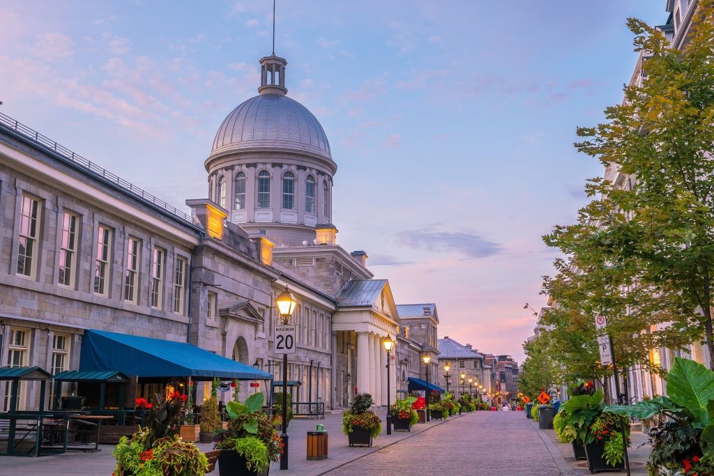 Historic white-domed building beside a flower-lined street at sunset