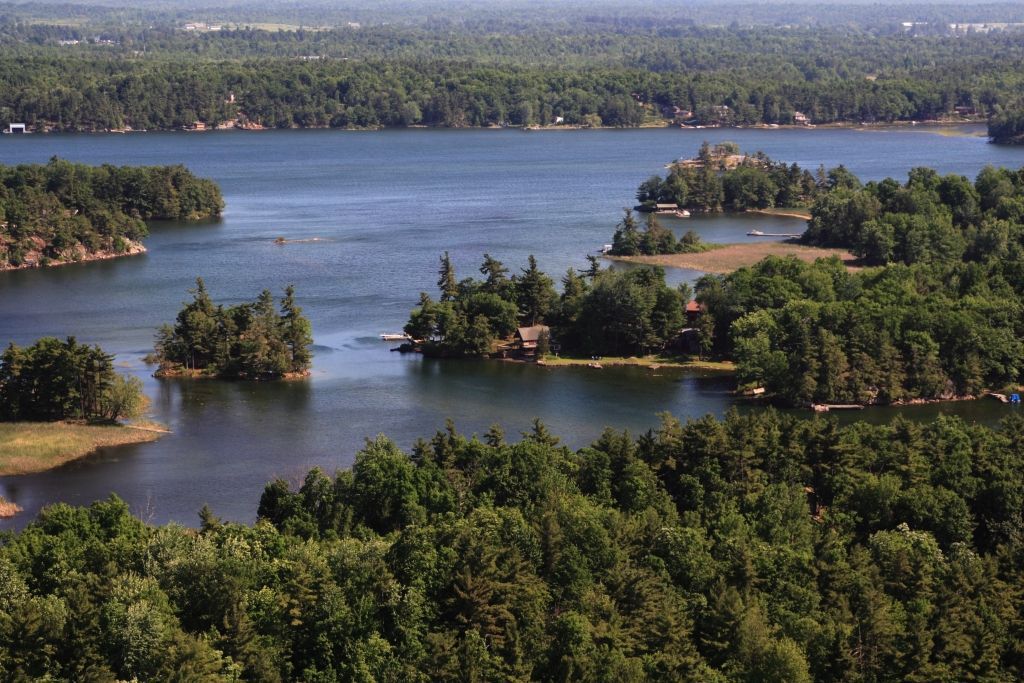 Forest-covered islands in a calm blue lake, viewed from above