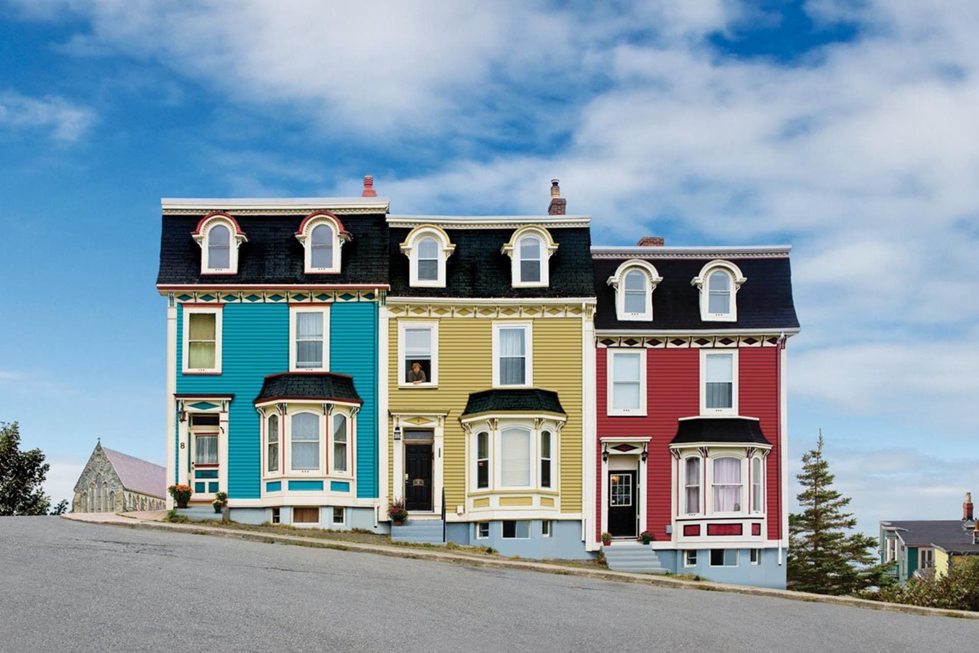 Colorful Victorian houses on a hill under a blue sky