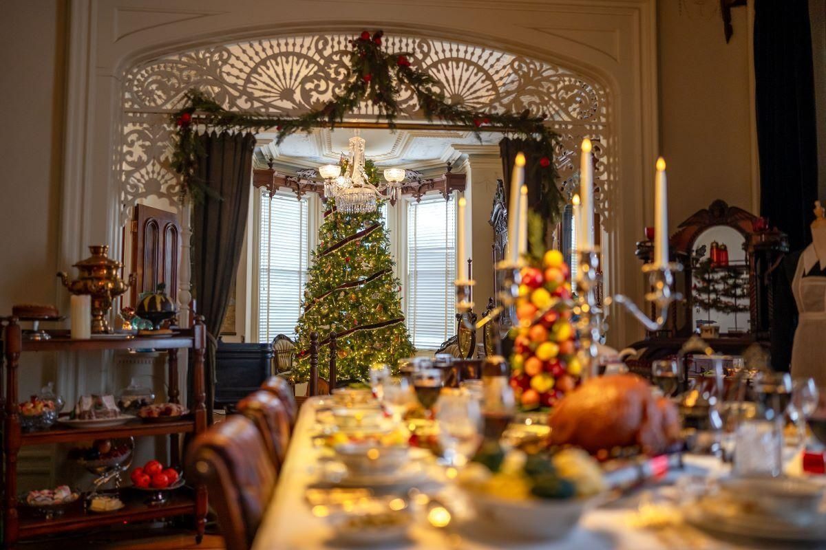 Festive dining room with a decorated Christmas tree and holiday table centerpiece