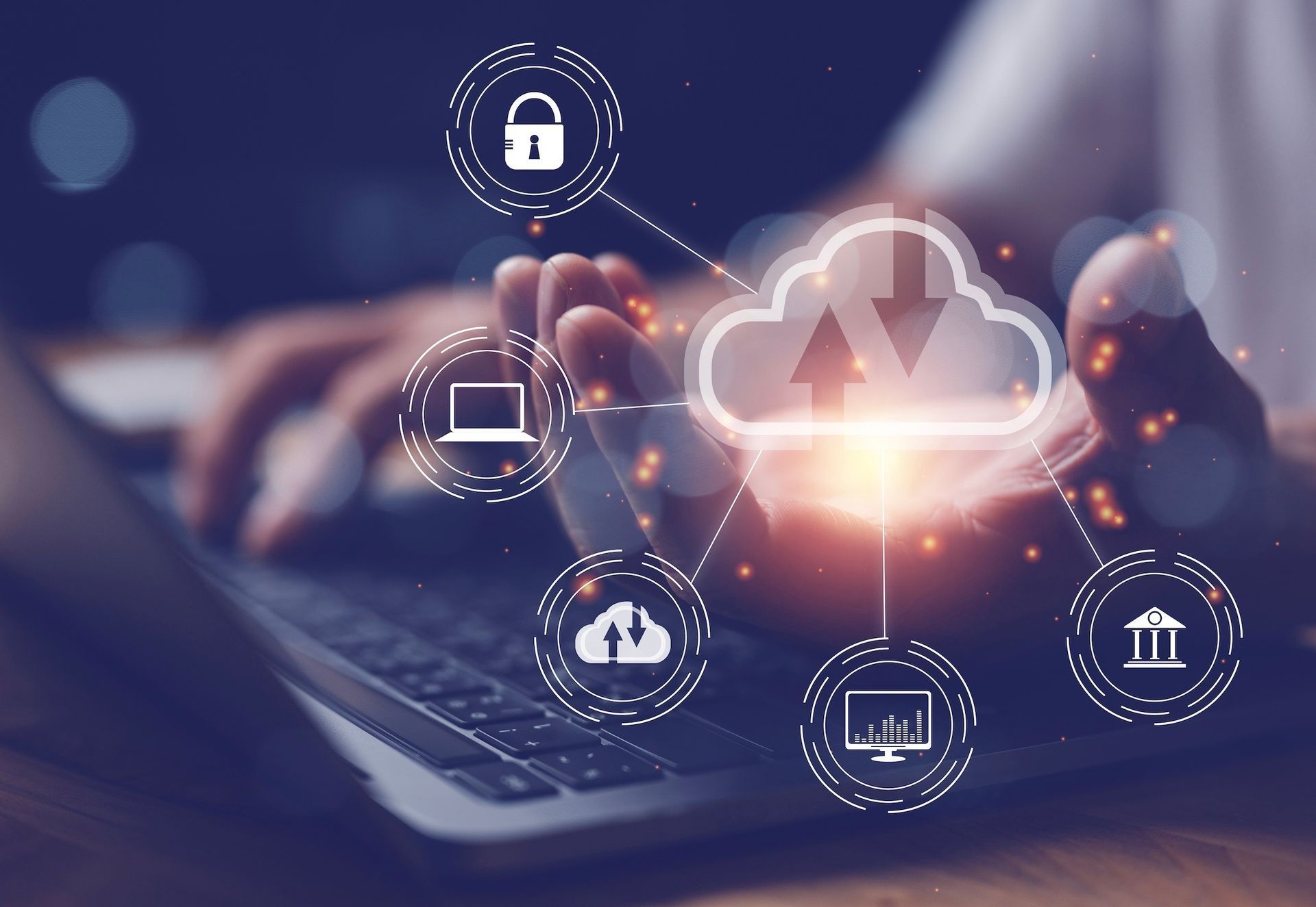 Hands using a laptop with glowing cloud computing and security icons in a dark blue digital interface