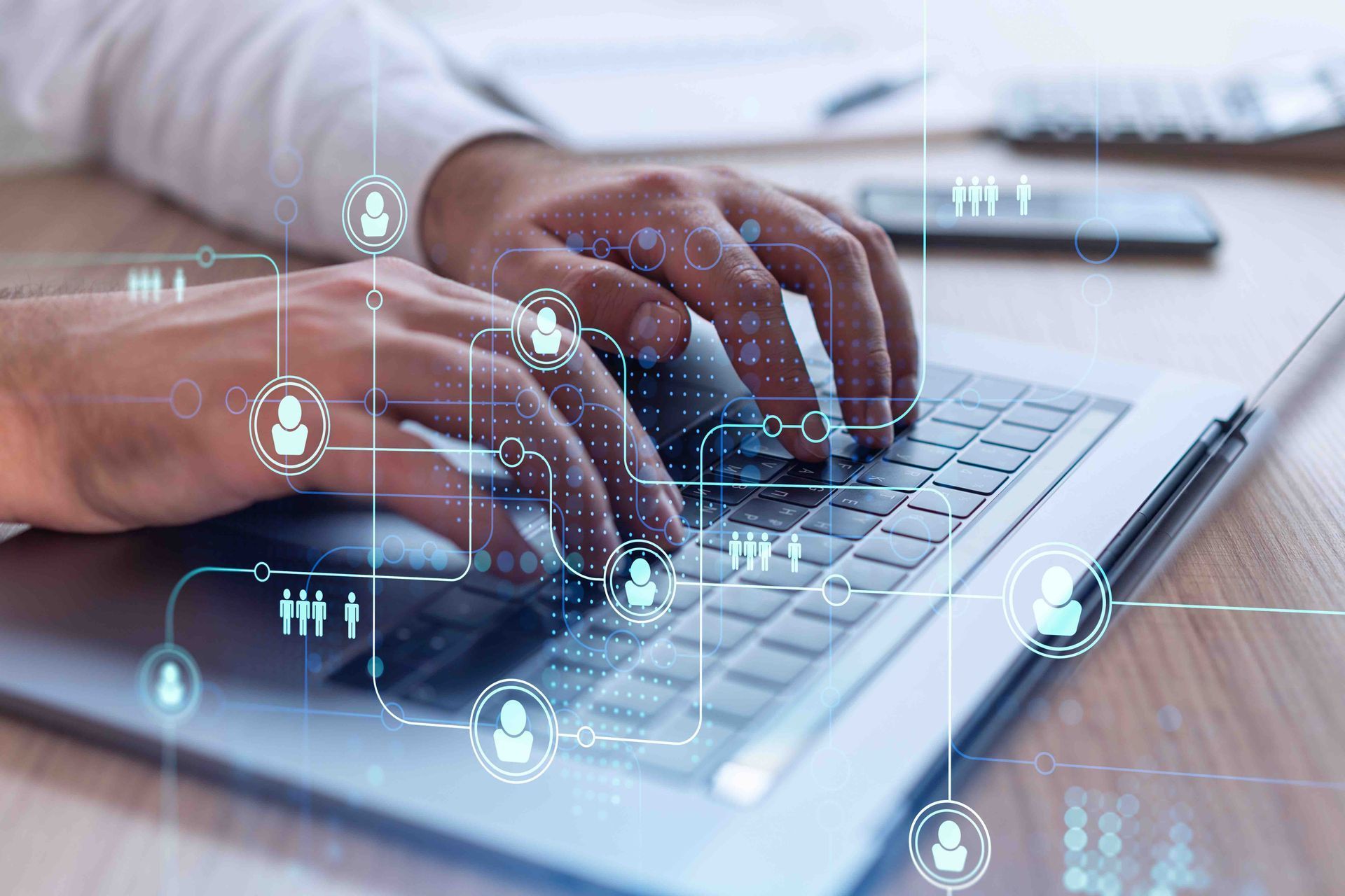 Hands typing on a laptop with digital interface icons overlaid on the keyboard