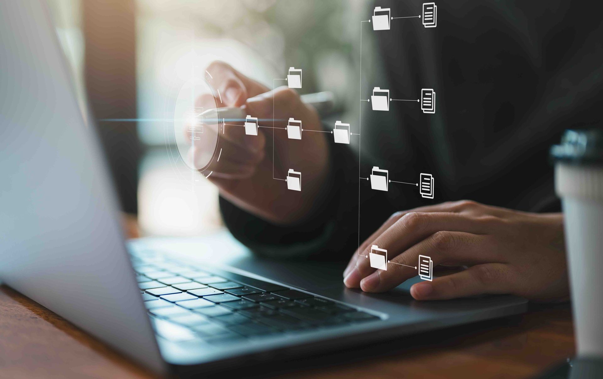 Hands typing on a laptop with floating digital interface icons over the screen