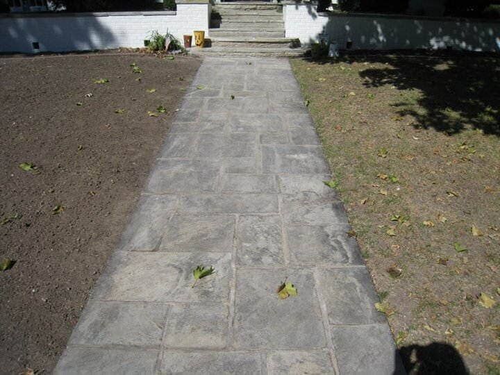 A stone walkway leading to a house with stairs