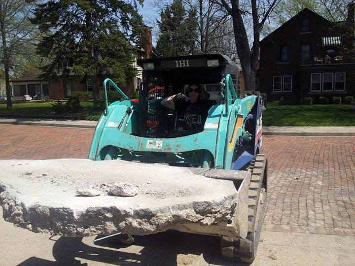 A bulldozer is carrying a large piece of concrete
