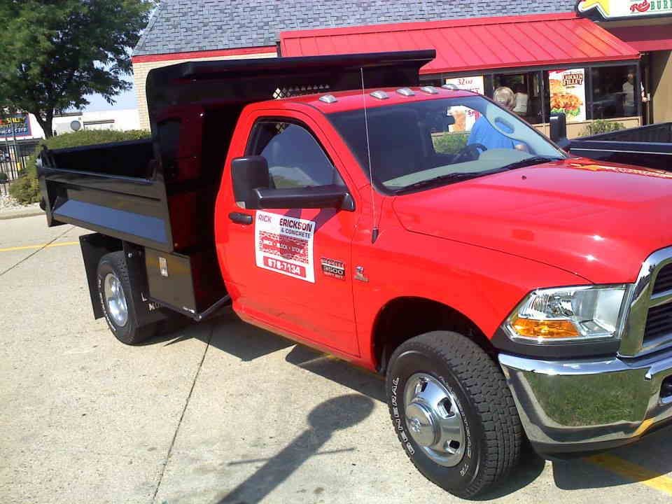 A red dump truck is parked in front of a restaurant