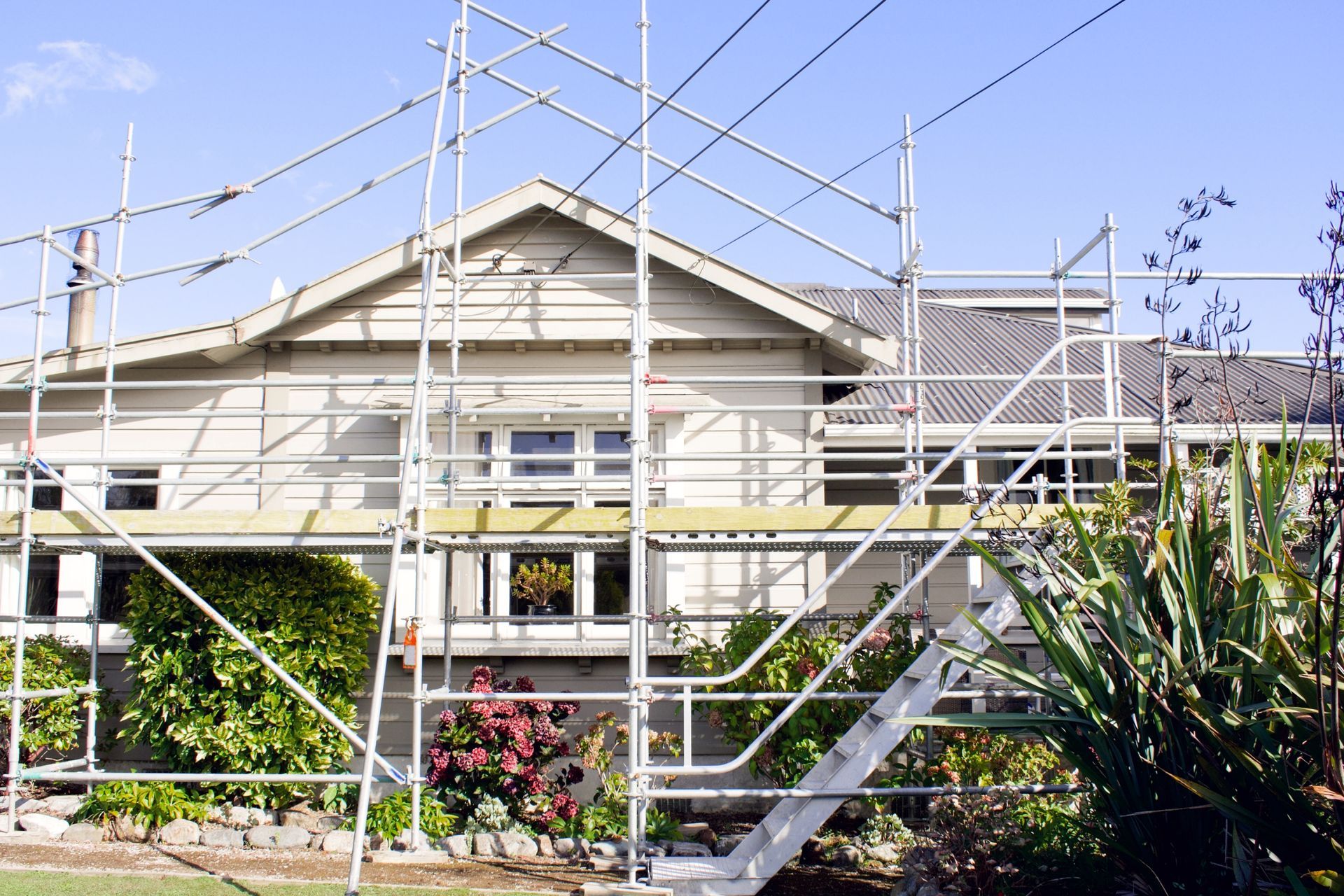 A house is being remodeled with scaffolding and stairs.