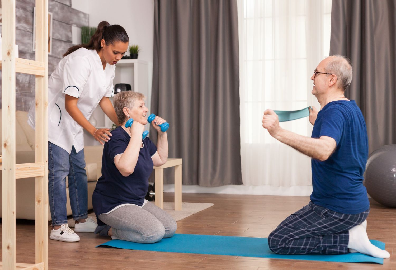 An instructor guides a person performing dumbbell exercises while another person stretches with a resistance band.