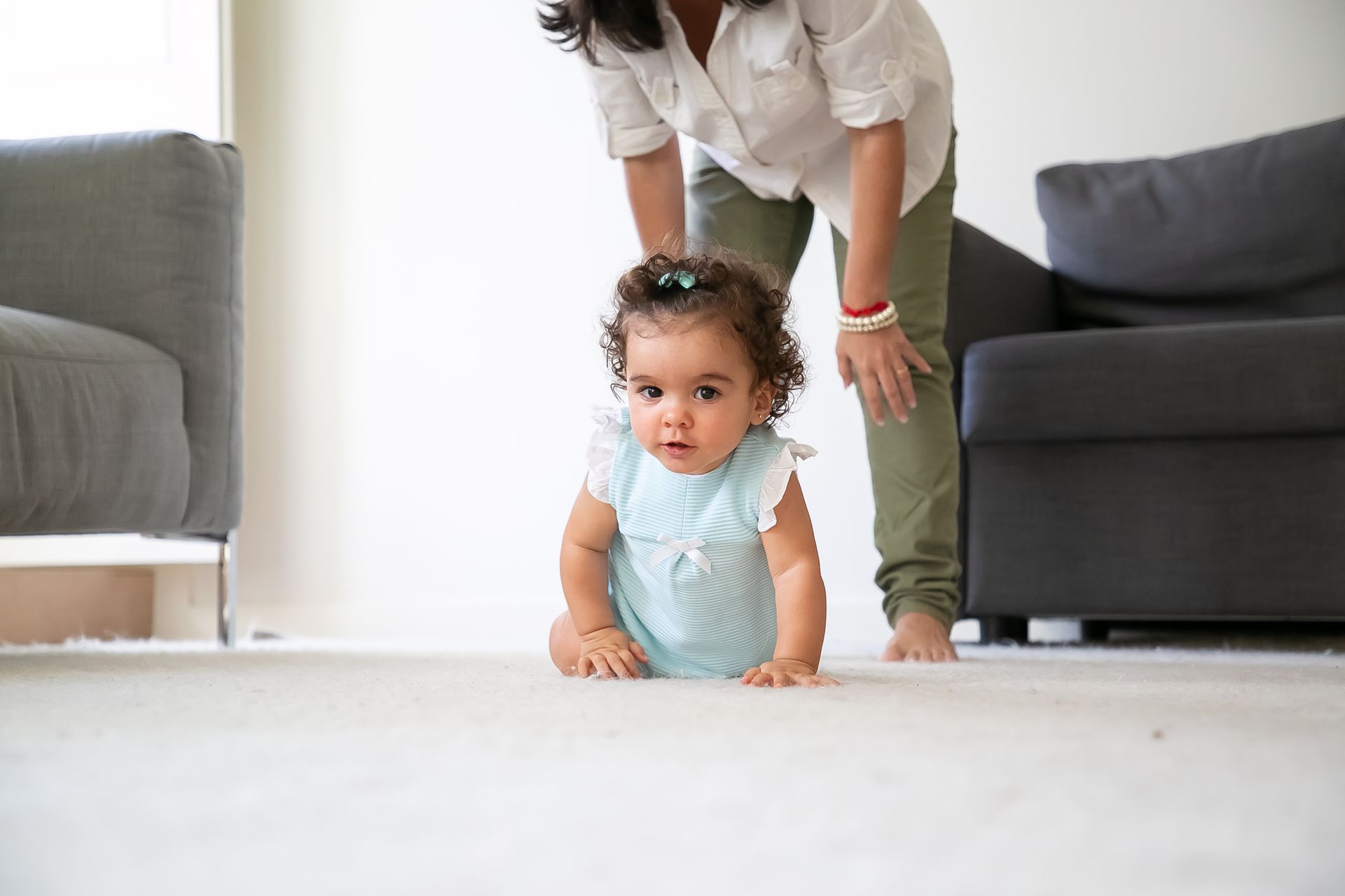 a baby girl in a blue dress is crawling on the floor
