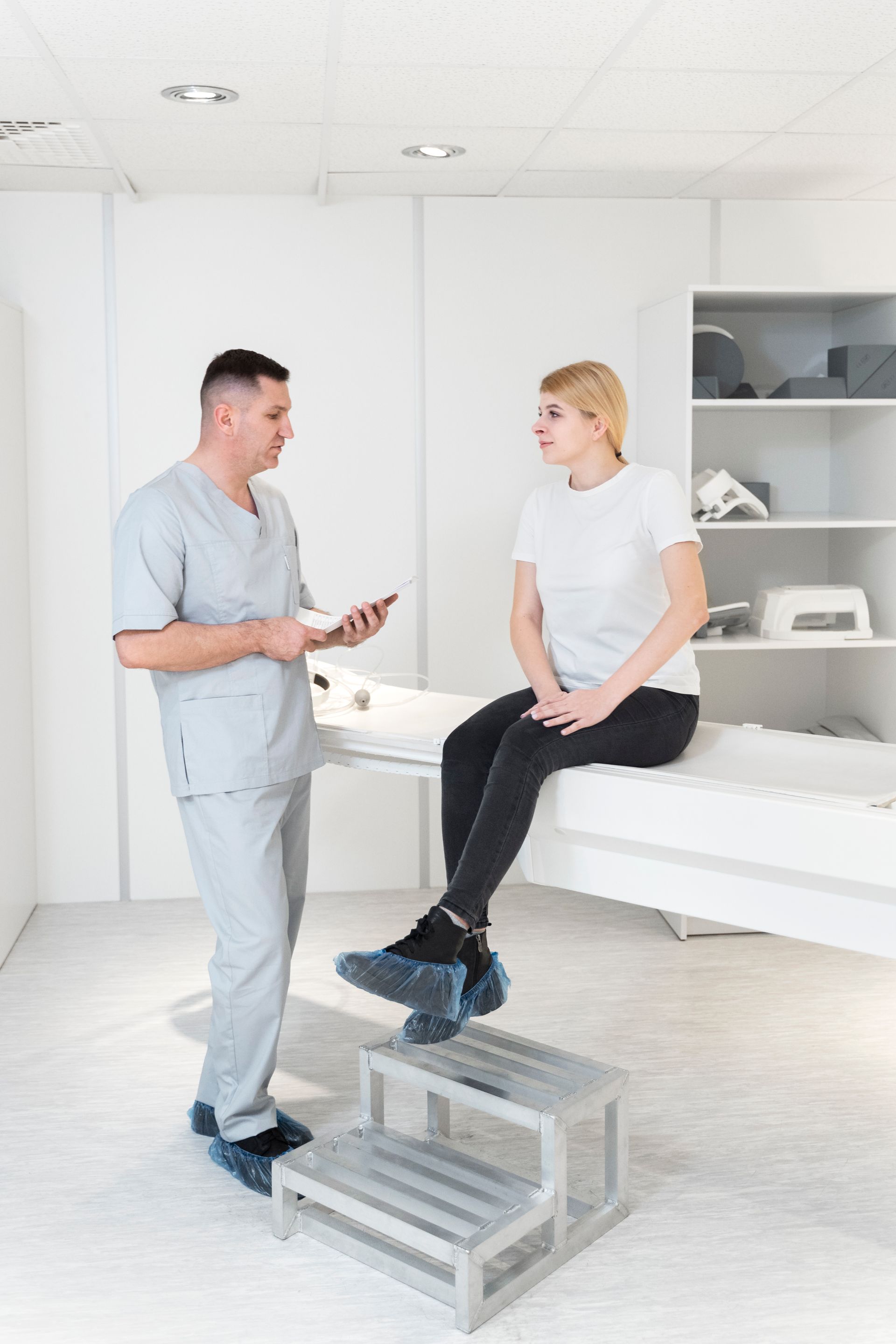 a doctor is talking to a patient who is sitting on a bed