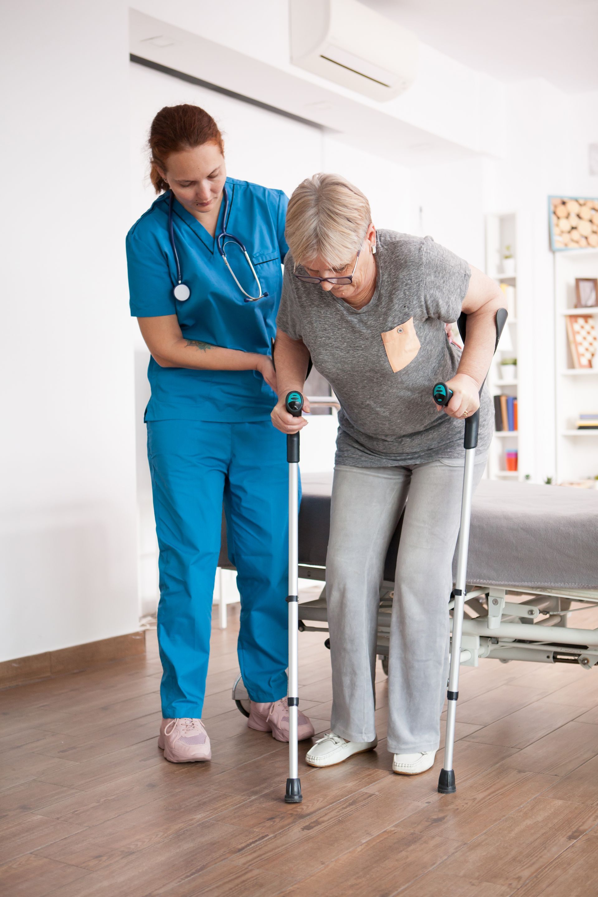Nurse assisting an elderly patient walking with a walker in a bright care facility