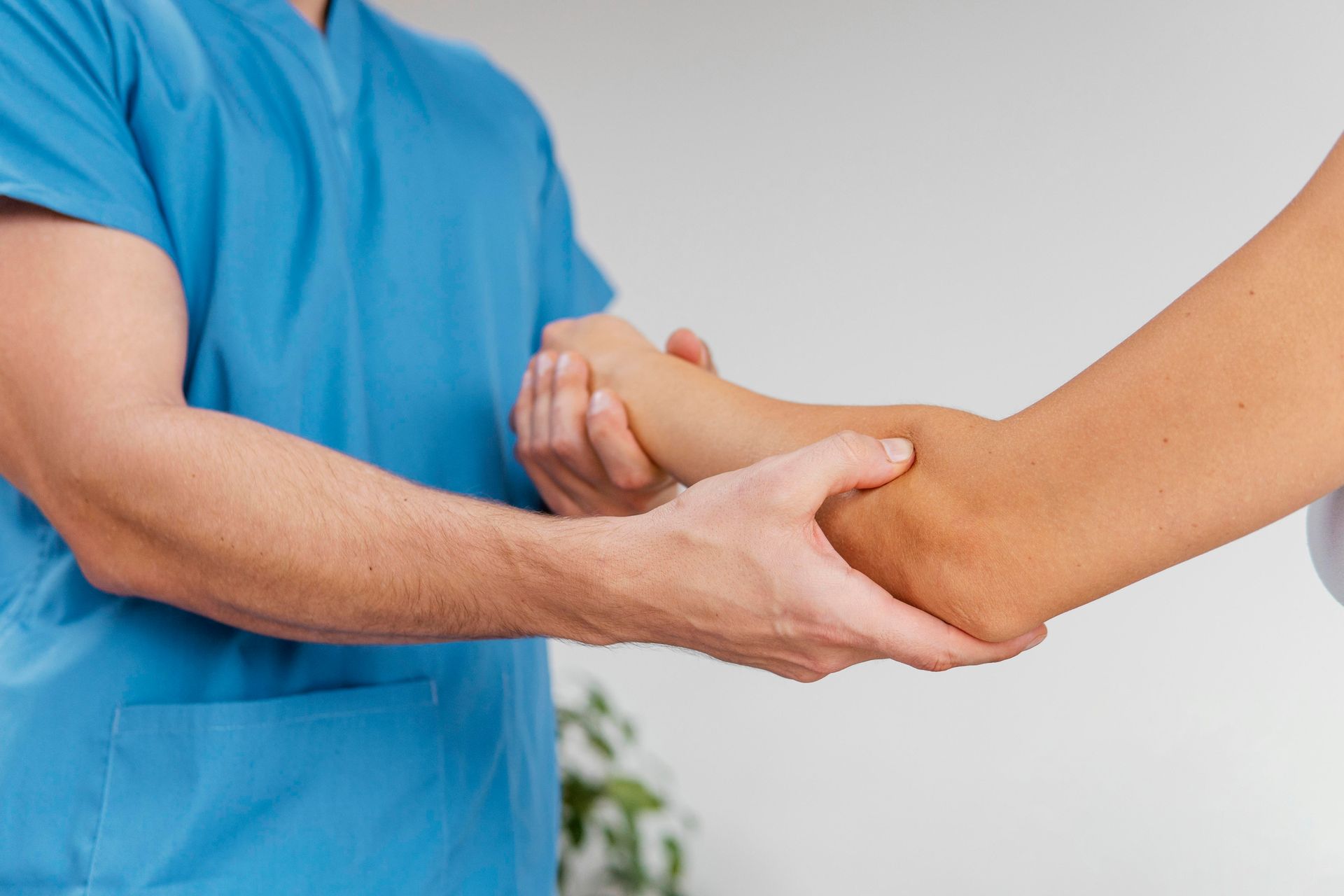 therapist checking female patient's elbow