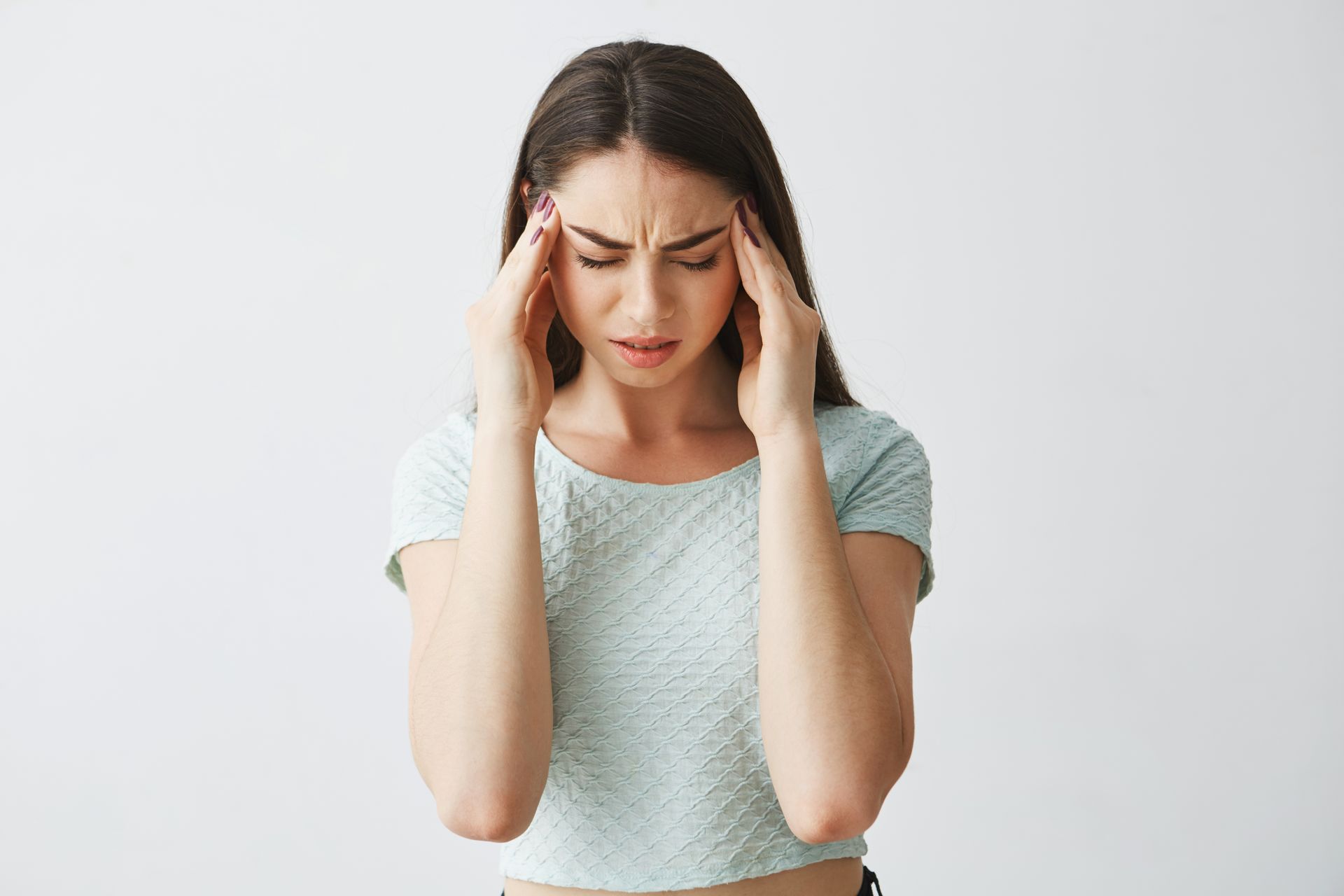 a woman is holding her head with her eyes closed