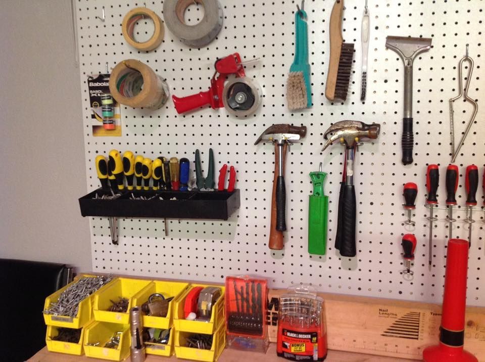 Tool organization: tools hanging on a pegboard, small parts bins on a workbench.