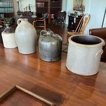 Assortment of stoneware crocks and jars on a wooden table.
