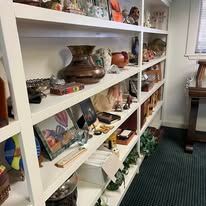 White shelves filled with various objects, including vases, ornaments, and books.