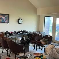 A room with items for sale; chairs, tables, and boxes.