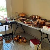 Table laden with copper pots and kitchenware.