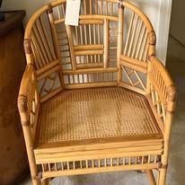 Wicker chair with a light brown frame and woven seat, indoors.