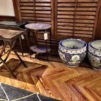 Wooden furniture: two side tables, one with a plant pot on top, and a patterned floor.