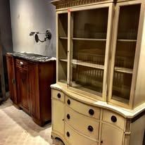 Wooden cabinet with glass doors next to a wooden dresser.