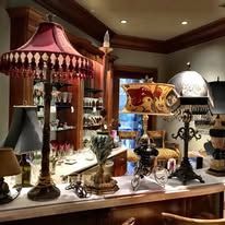 Vintage lamps in a dining room: maroon shade, ornate bases, on a bar.