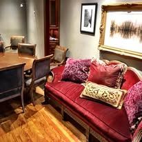 Living room with a red couch, artwork, and wood floors.