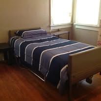 Bedroom with a bed covered in blue and gray striped bedding.