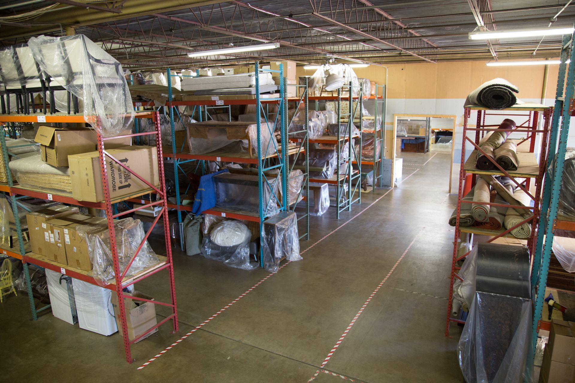 Warehouse interior with metal shelving filled with packaged goods.