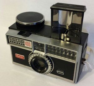 A kodak instamatic 400 camera is sitting on a white surface
