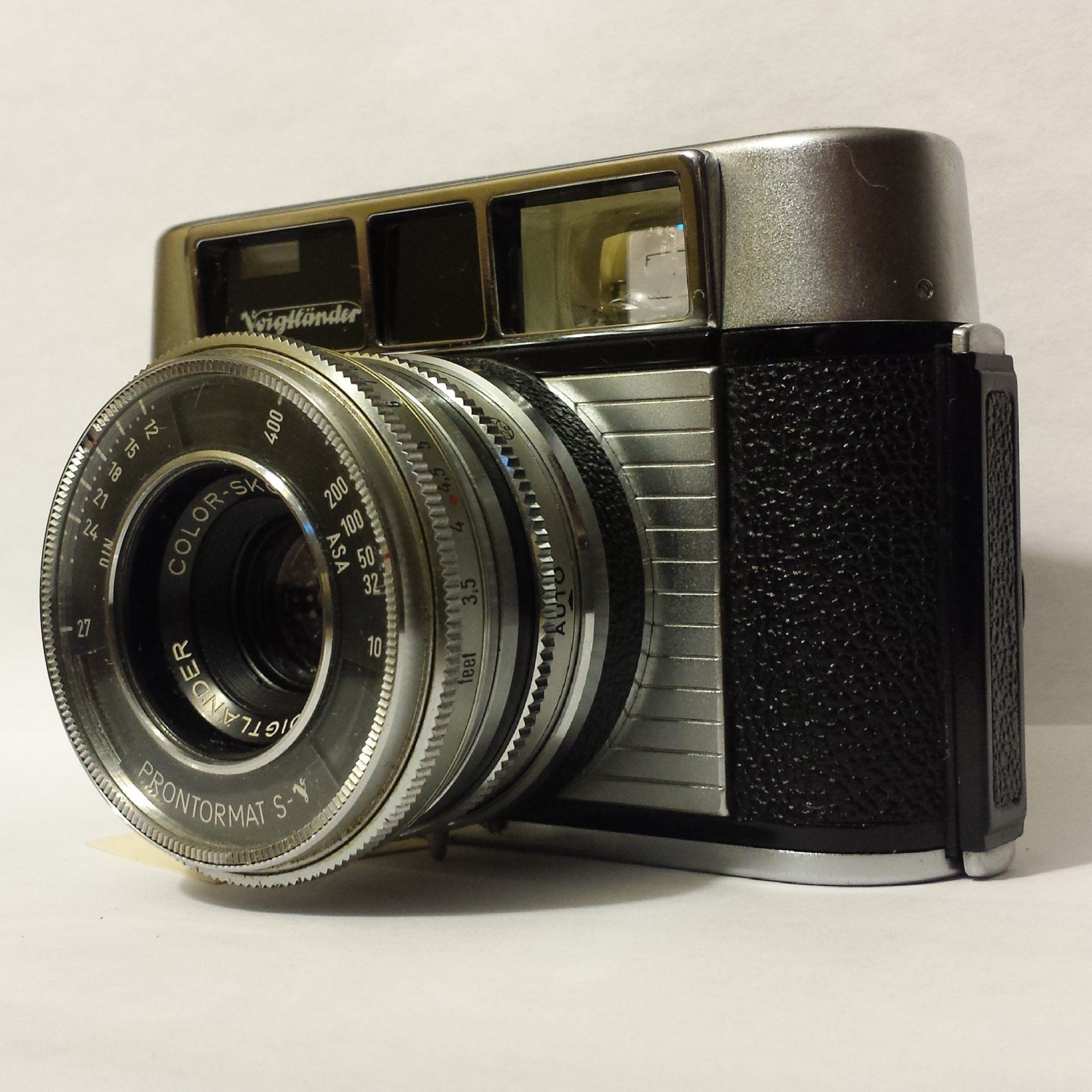 A silver and black camera with a lens that says ' sigma ' on it
