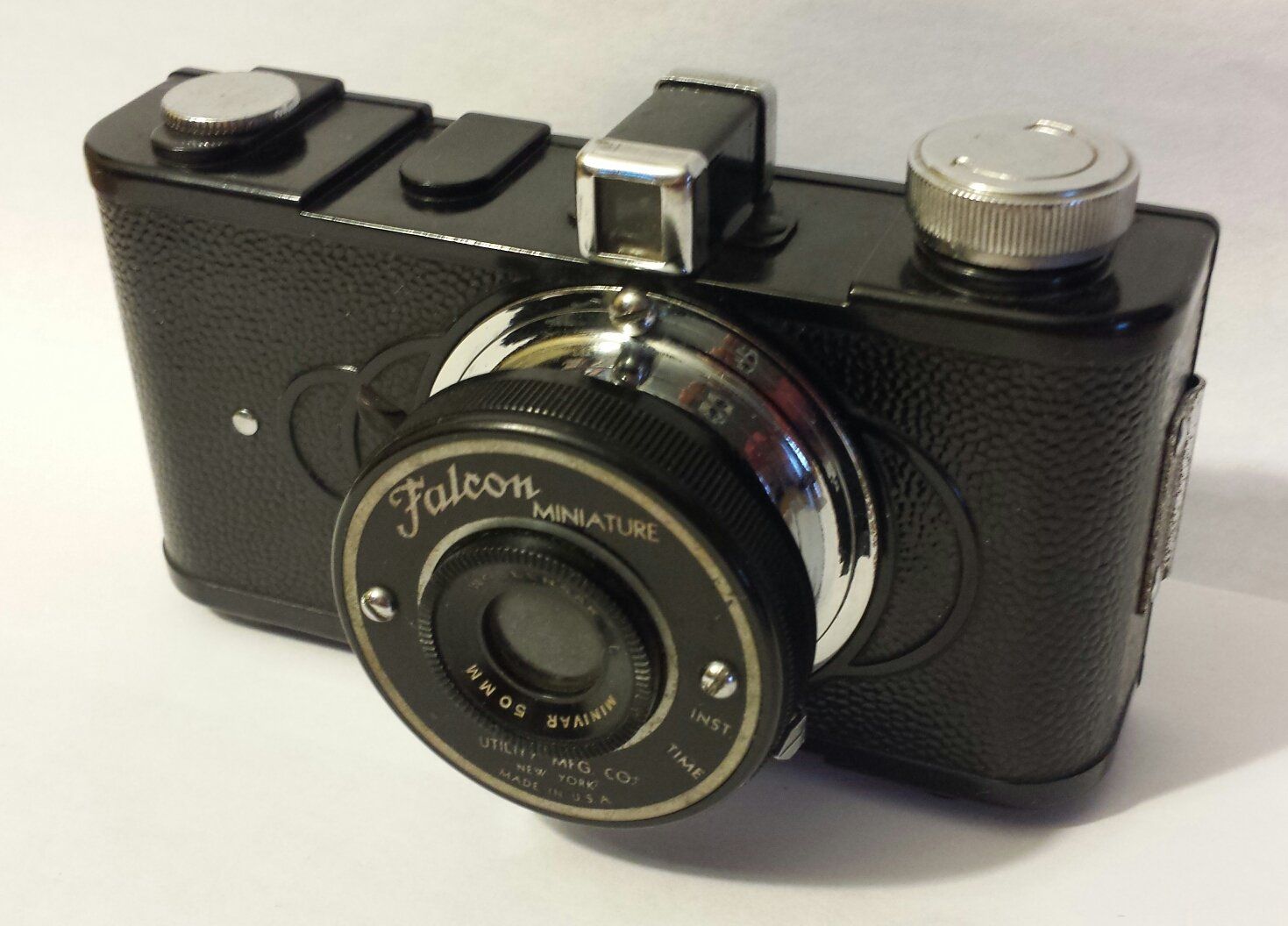 A black falcon camera is sitting on a white surface