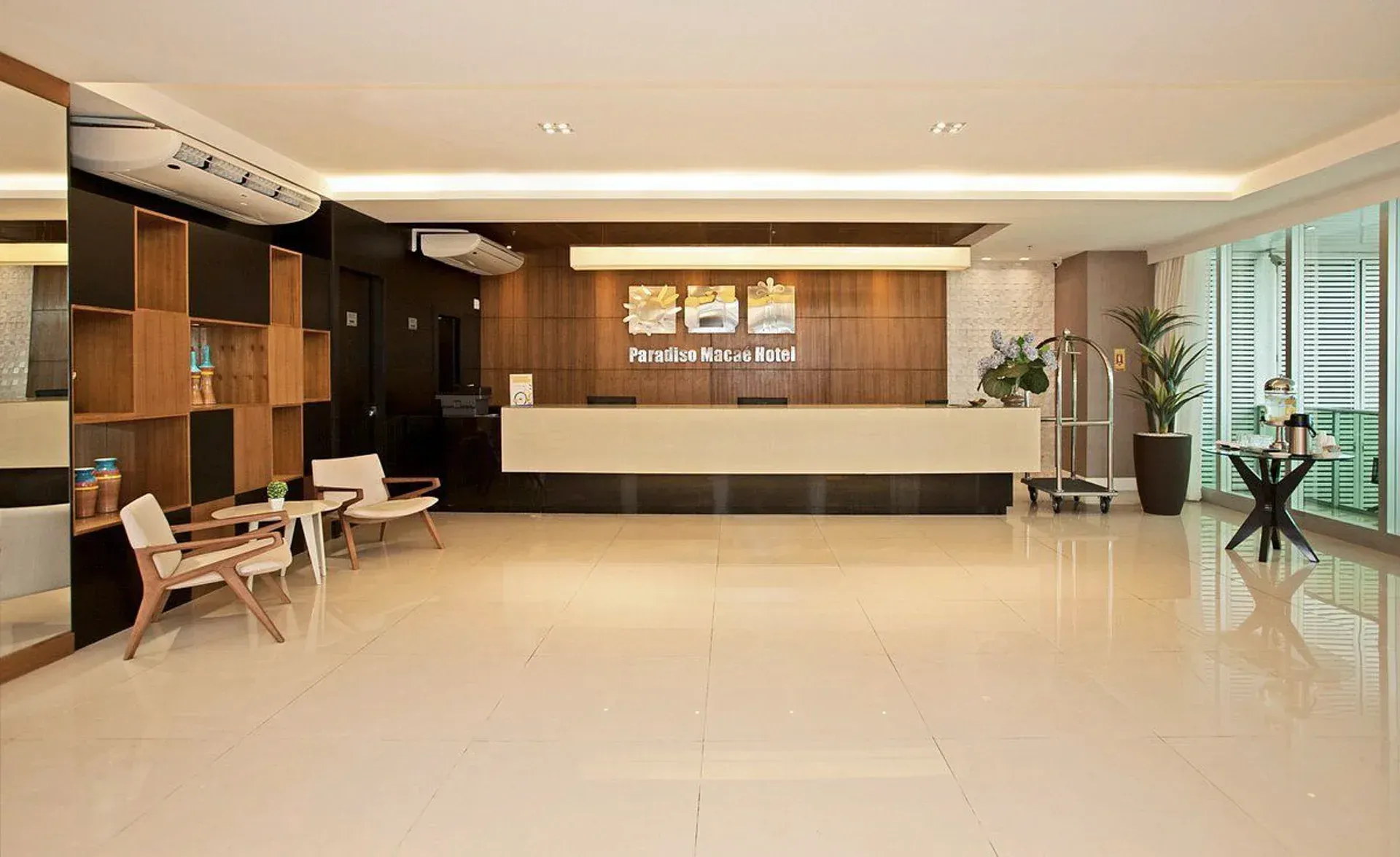 Hall de entrada moderno com piso de azulejos brilhantes, parede com painéis de madeira, recanto com assentos.